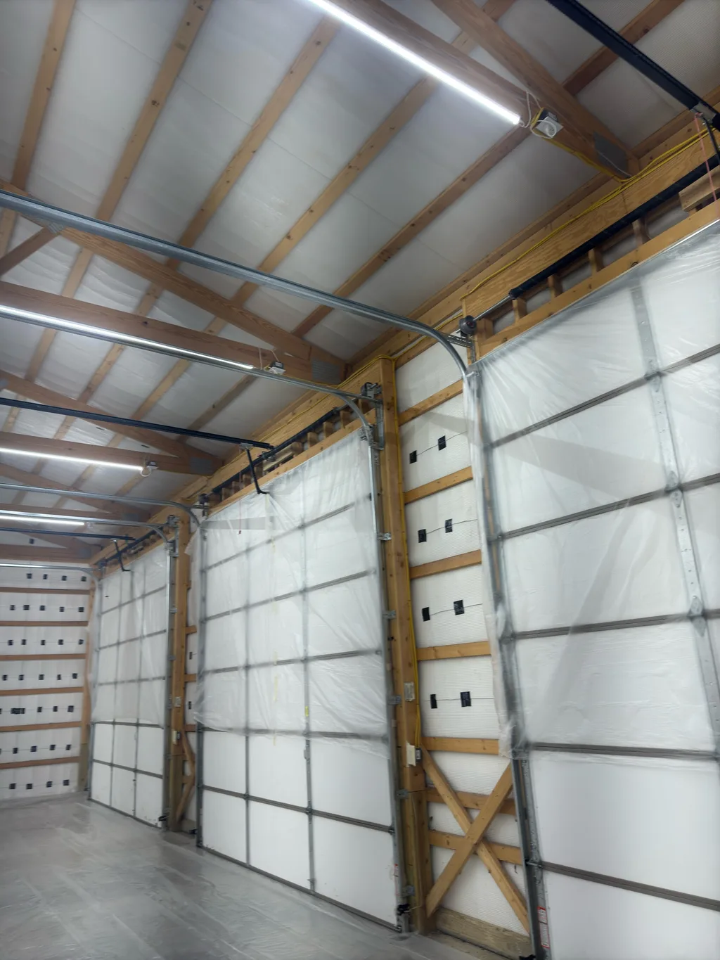 Lined barn interior with an overhead door and its track running along the wall