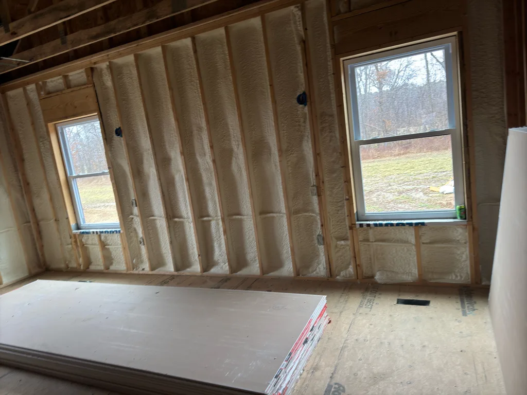 Foamed stud wall with two windows onto bare winter fields and a panel on the floor