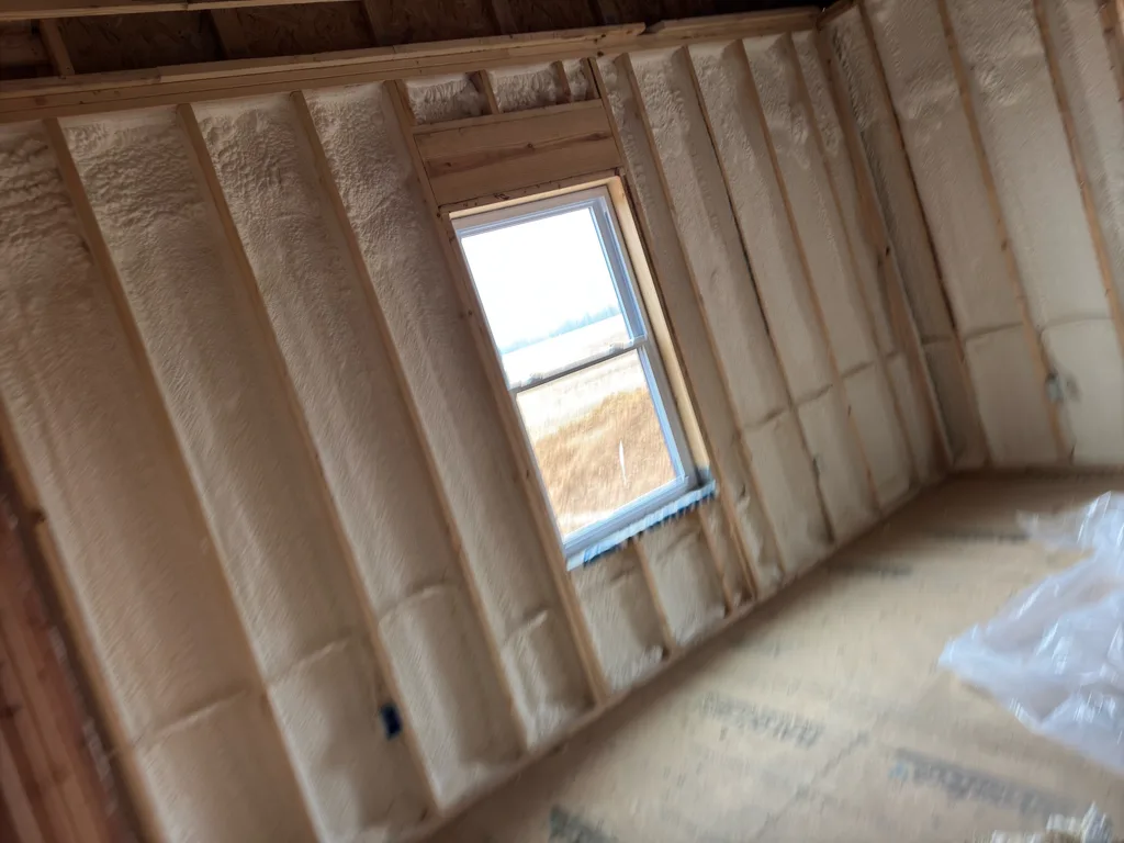 Foamed wall bays framing a single window that looks out over a bare winter field