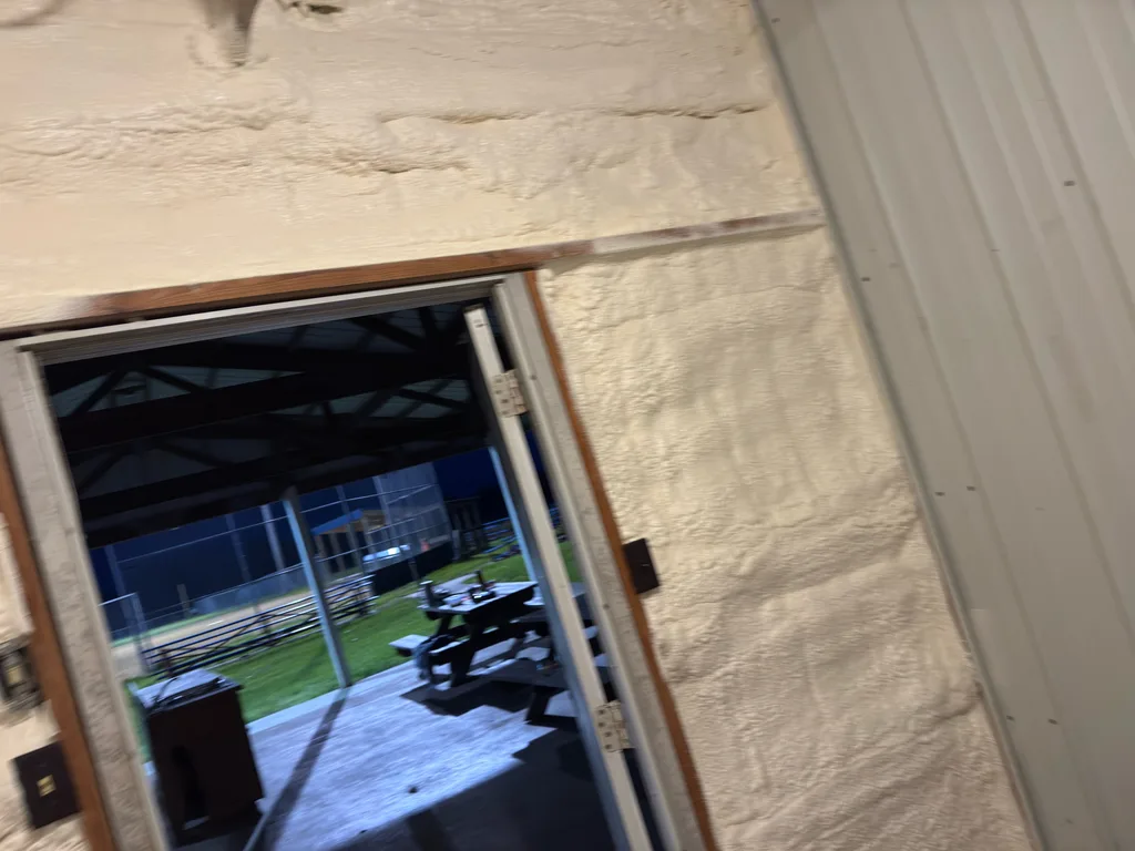 Foamed wall around a doorway opening onto a covered area with a picnic table
